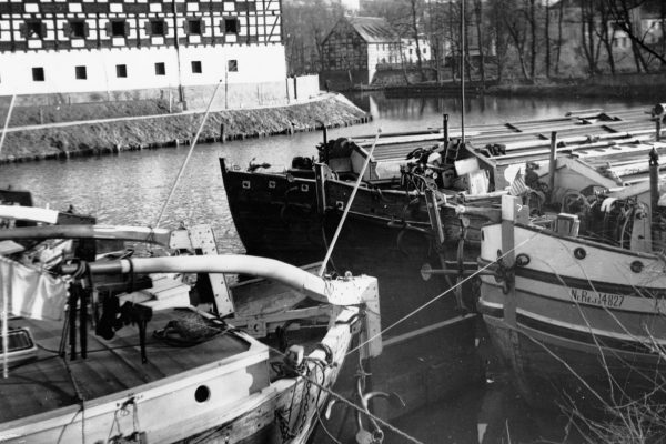 Barki zacumowane przy brzegu, w głębi widoczny fragment budynku spichlerza, 1938 r., źródło: Narodowe Archiwum Cyfrowe