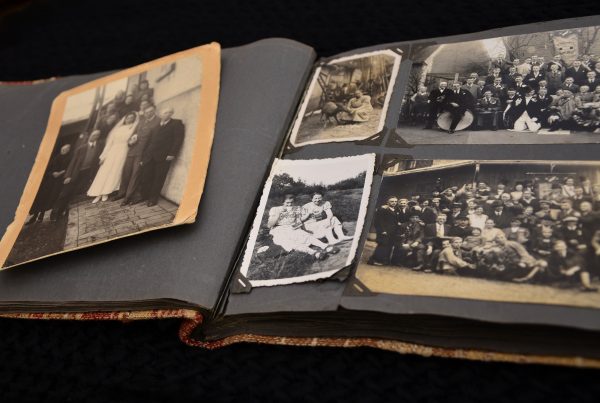 zdjęcie przedstawiające otwarty stary album z czarno-białymi fotografiami rodzinnymi